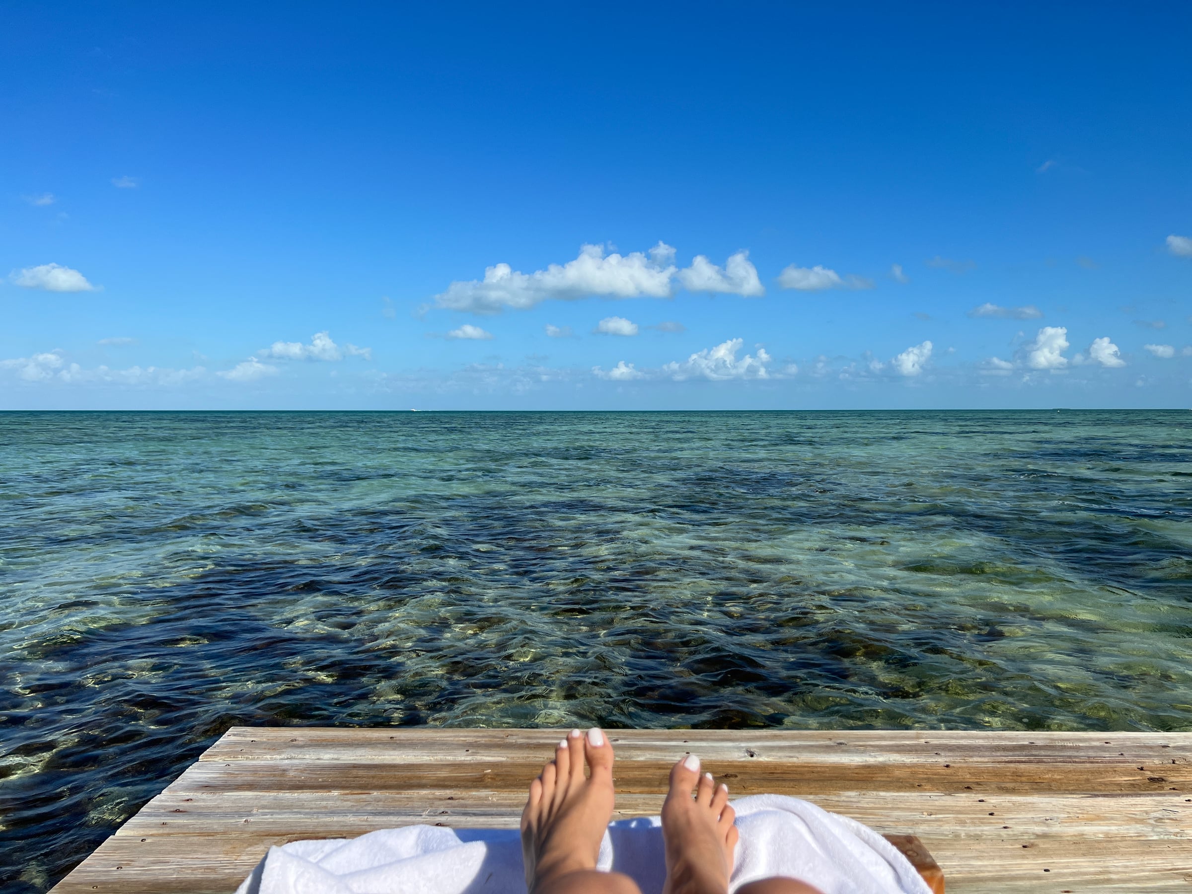 Feet up over turquoise water on a boat